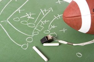 A diagram of a football play on a chalkboard with a football,